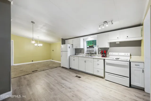 a kitchen with white cabinets and white appliances