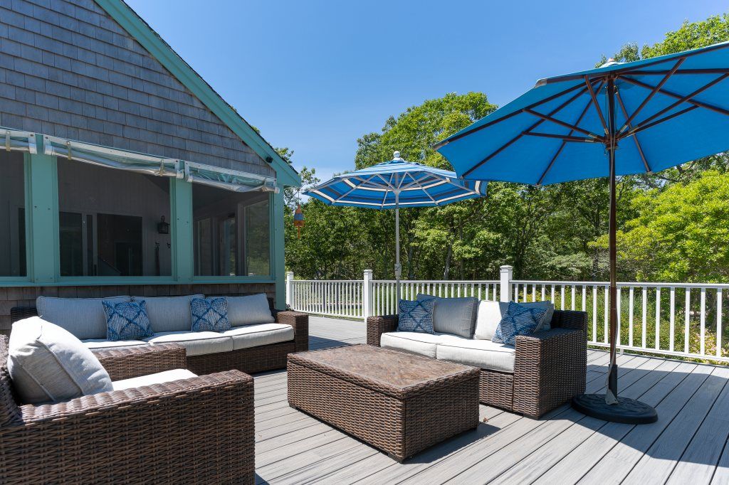 33 Codman Spring Road Edgartown, MA 02539 - Photo 6 of 24 a view of a patio with couches and umbrella