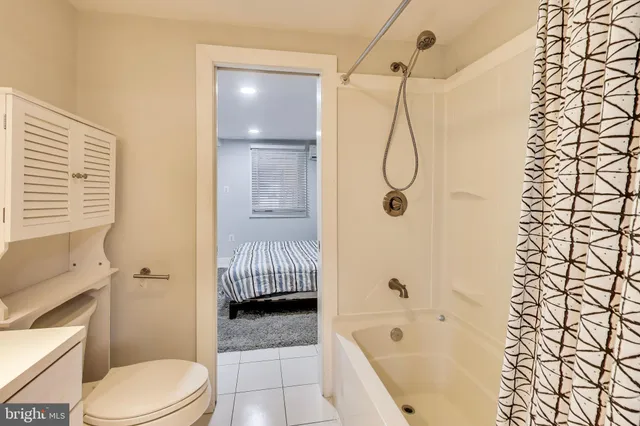 a bathroom with a bathtub shower sink vanity and toilet