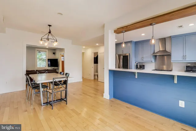 a living room with stainless steel appliances kitchen island granite countertop a dining table chairs stove a refrigerator and a kitchen view