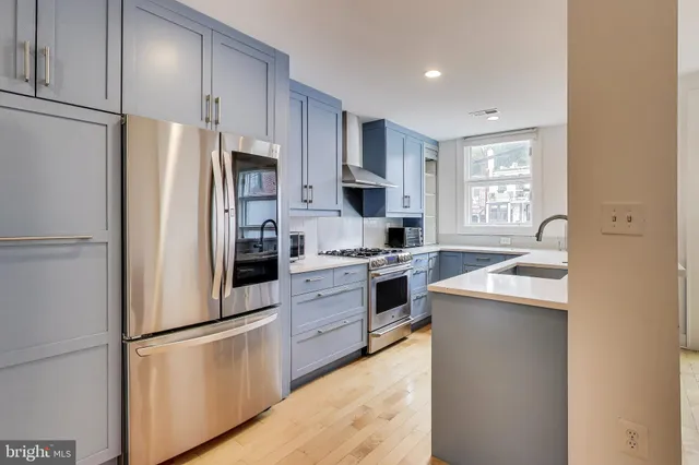 a kitchen with stainless steel appliances a refrigerator sink and white cabinets