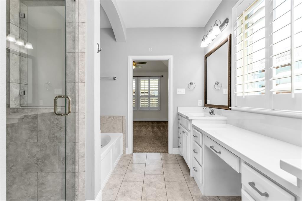 15713 Canyon Ridge Prosper, TX 75078 - Photo 26 of 38 Bathroom featuring a glass-enclosed shower with tile surround, a separate soaking tub, and a vanity with dual sinks