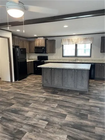 a living room with stainless steel appliances kitchen island granite countertop a stove and a sink