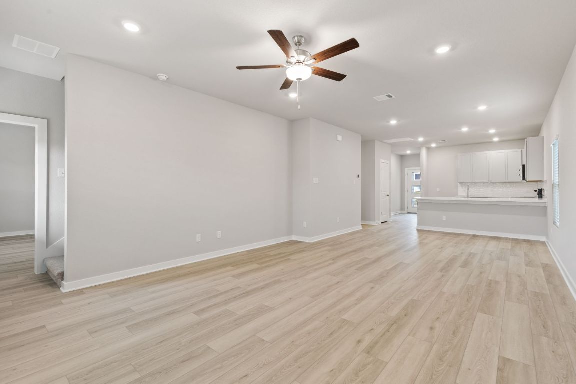 212 Lazy Lizzy Road Jarrell, TX 76537 - Photo 12 of 30 wooden floor in an empty room with a ceiling fan