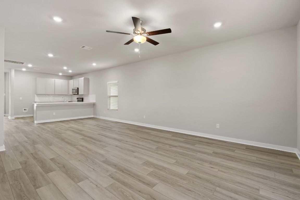 212 Lazy Lizzy Road Jarrell, TX 76537 - Photo 13 of 30 wooden floor in an empty room with a ceiling fan