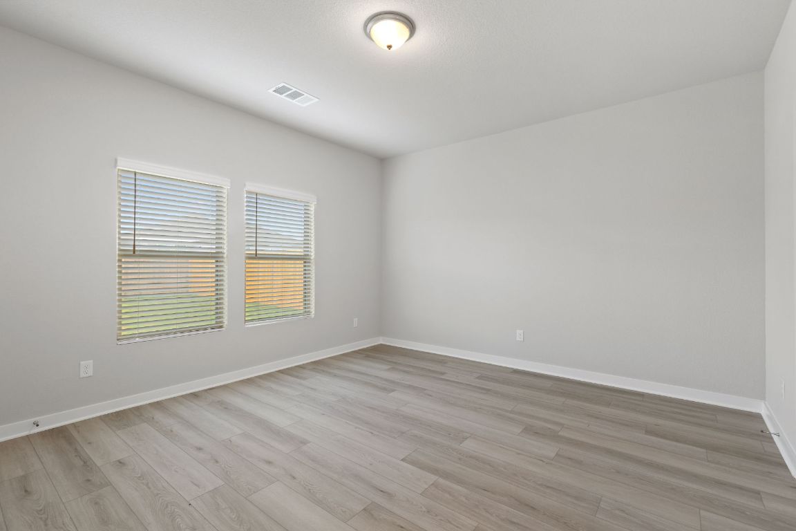 212 Lazy Lizzy Road Jarrell, TX 76537 - Photo 14 of 30 an empty room with wooden floor and windows