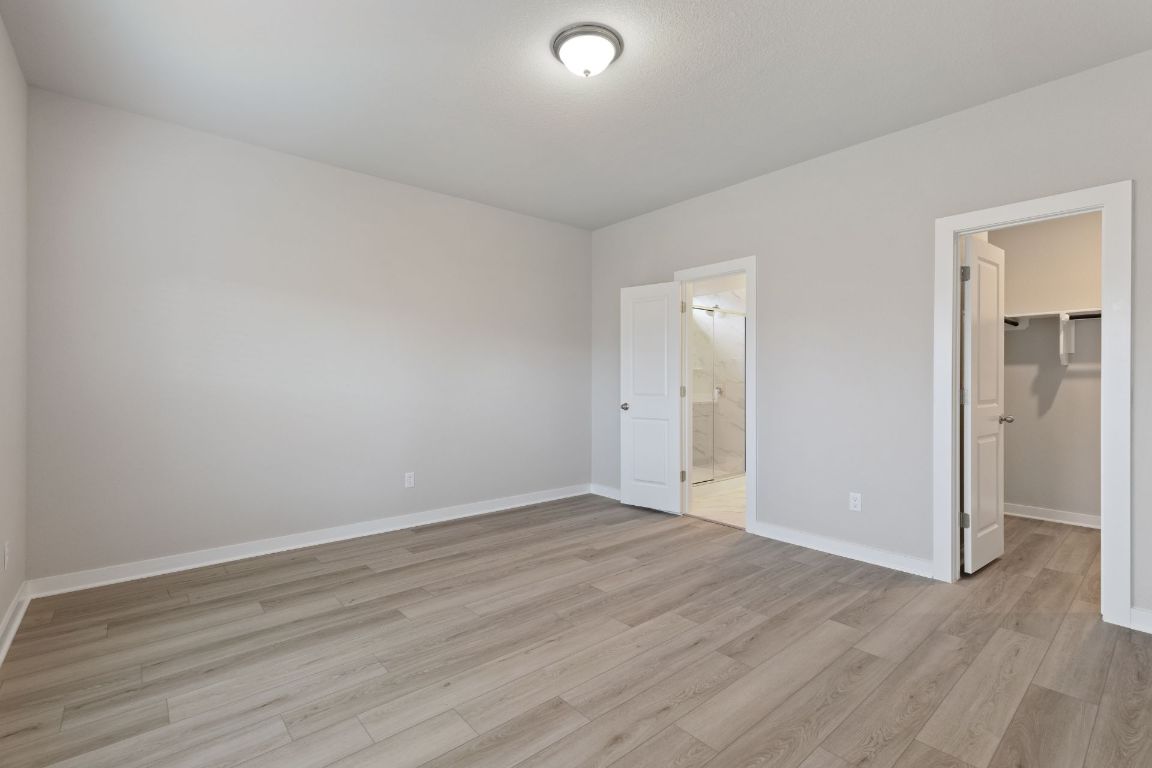 212 Lazy Lizzy Road Jarrell, TX 76537 - Photo 15 of 30 a view of an empty room with wooden floor and closet