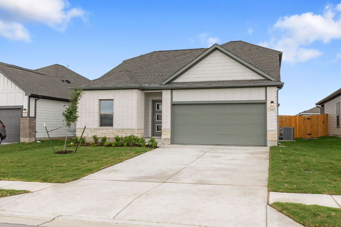 212 Lazy Lizzy Road Jarrell, TX 76537 - Photo 2 of 30 a front view of a house with a yard and garage