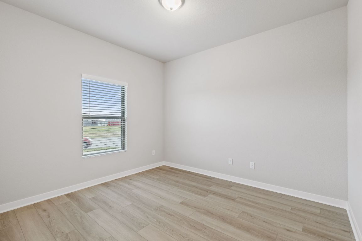 212 Lazy Lizzy Road Jarrell, TX 76537 - Photo 23 of 30 an empty room with wooden floor and windows