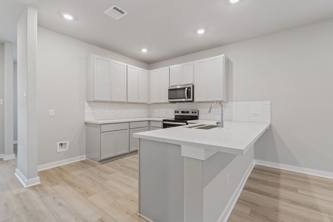 212 Lazy Lizzy Road Jarrell, TX 76537 - Photo 8 of 30 a kitchen with white cabinets appliances and sink