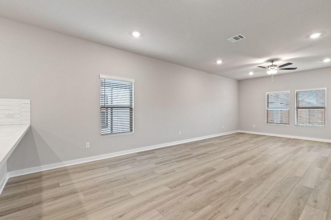 212 Lazy Lizzy Road Jarrell, TX 76537 - Photo 10 of 30 an empty room with wooden floor and windows