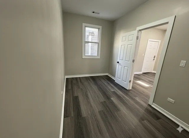 a view of a hallway with wooden floor and closet area
