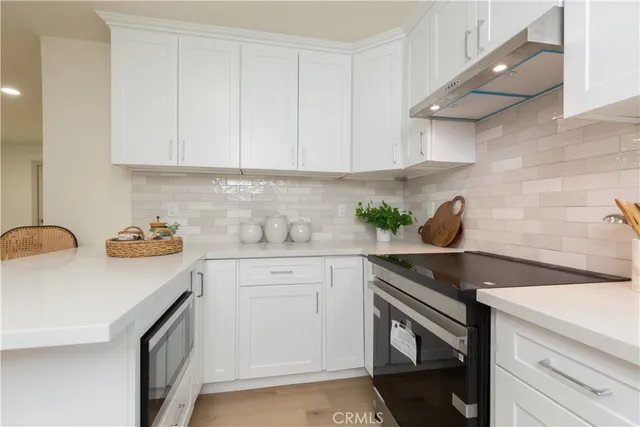 a kitchen with stainless steel appliances granite countertop white cabinets sink and dishwasher