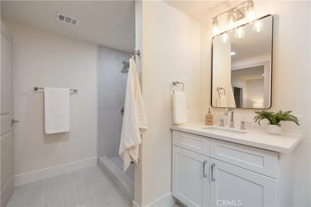 a bathroom with a bathtub sink vanity and mirror
