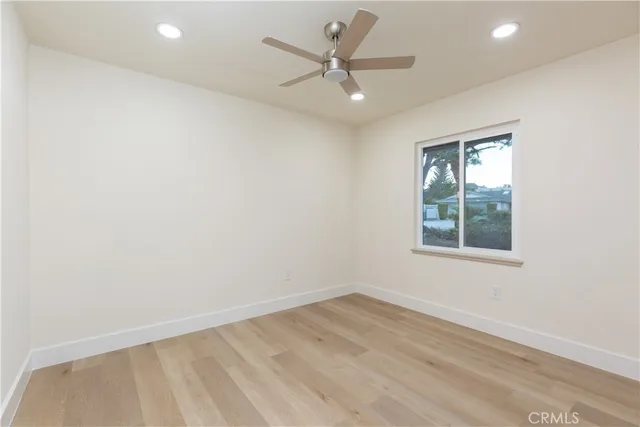 an empty room with a window and a fan