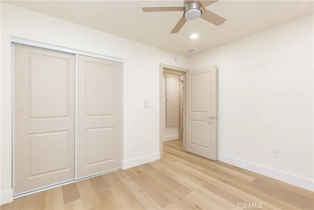 an empty room with fan and windows