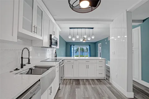 a kitchen with cabinets a sink and appliances