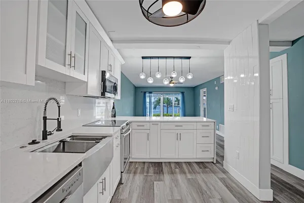 a kitchen with cabinets a sink and appliances