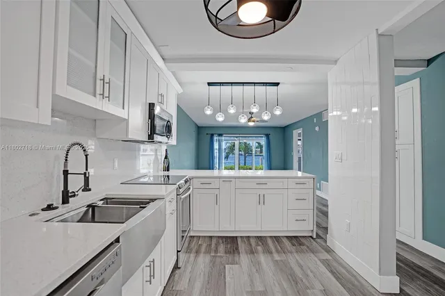 a kitchen with cabinets a sink and appliances