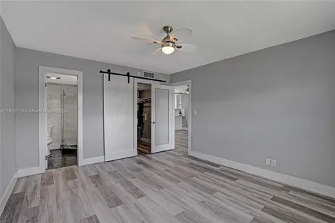 wooden floor in an empty room with a fan