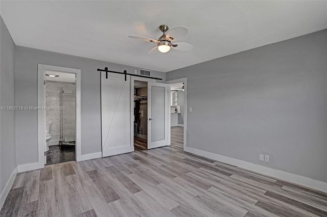 wooden floor in an empty room with a fan