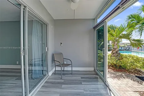 a view of a room that has a large window and wooden floor