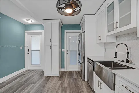 a view of a kitchen cabinets a sink and dishwasher with wooden floor