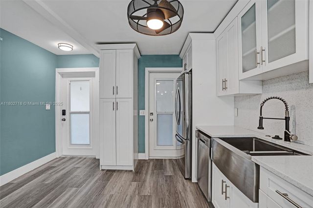 a view of a kitchen cabinets a sink and dishwasher with wooden floor