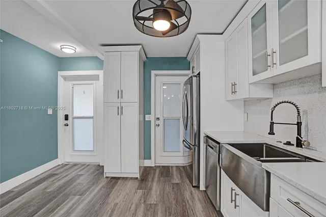 a view of a kitchen cabinets a sink and dishwasher with wooden floor