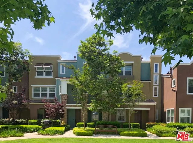 a front view of a multi story building with yard