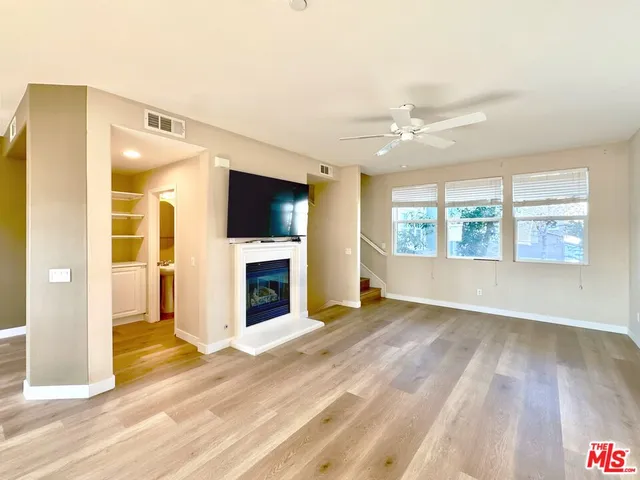 a view of an empty room with a fireplace and a window