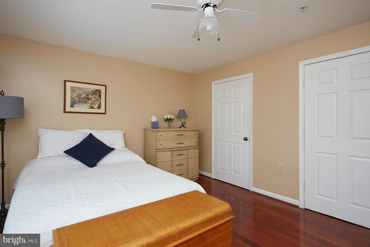 115 Timberbrook Lane, Unit 104 Gaithersburg, MD 20878 - Photo 12 of 28 a bedroom with a bed and wooden floor