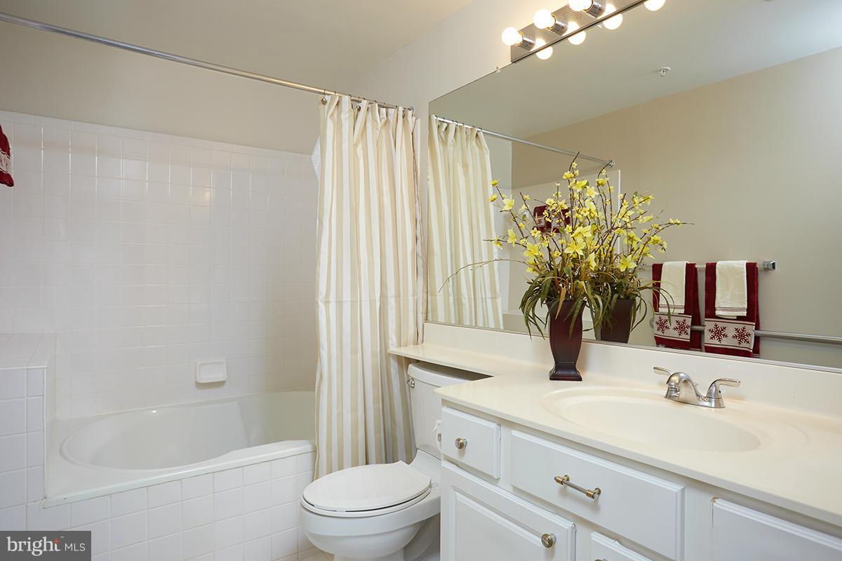 115 Timberbrook Lane, Unit 104 Gaithersburg, MD 20878 - Photo 15 of 28 a bathroom with a granite countertop sink a toilet and shower