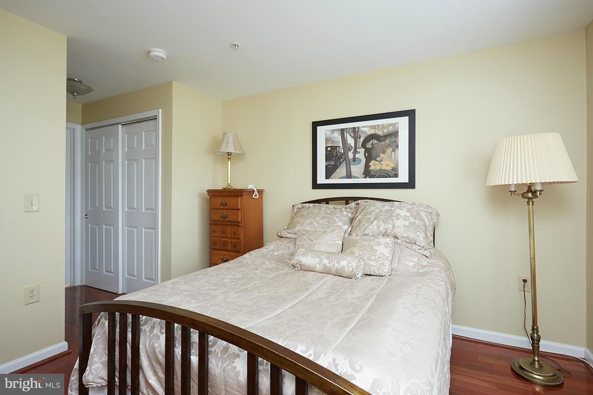115 Timberbrook Lane, Unit 104 Gaithersburg, MD 20878 - Photo 18 of 28 a bedroom with a bed and a lamp on table