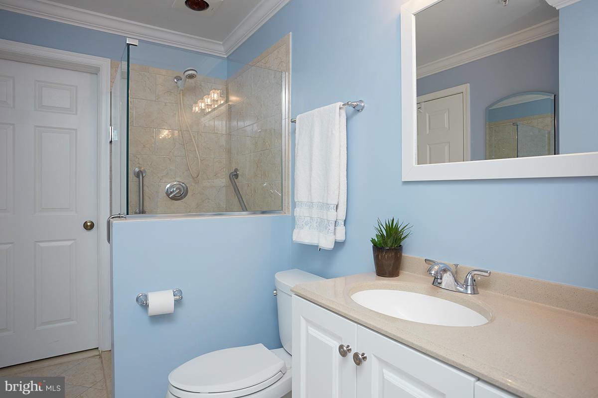 115 Timberbrook Lane, Unit 104 Gaithersburg, MD 20878 - Photo 19 of 28 a bathroom with a granite countertop sink mirror and a toilet