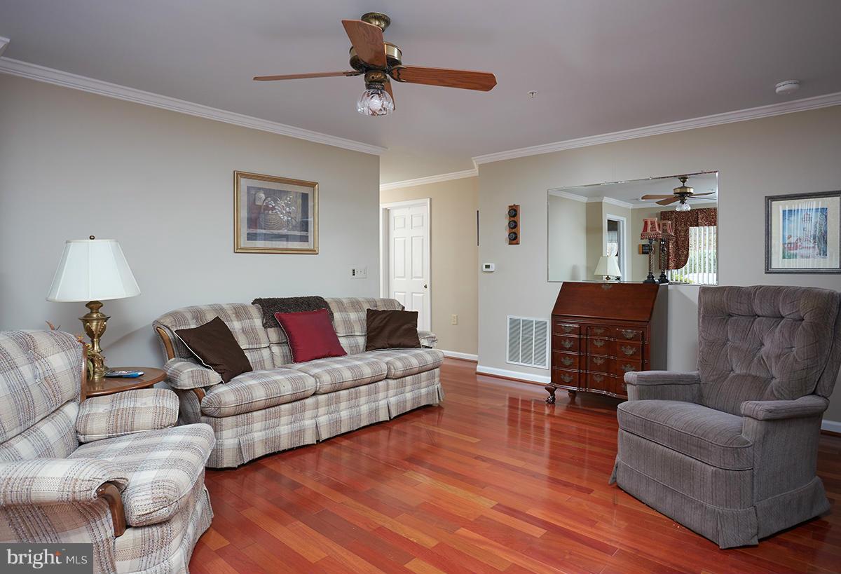 115 Timberbrook Lane, Unit 104 Gaithersburg, MD 20878 - Photo 4 of 28 a living room with furniture and a wooden floor