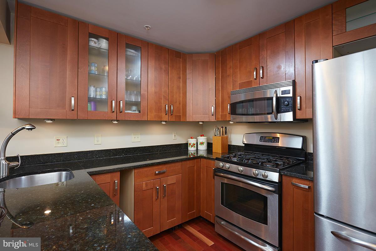 115 Timberbrook Lane, Unit 104 Gaithersburg, MD 20878 - Photo 7 of 28 a kitchen with stainless steel appliances a stove a microwave and sink