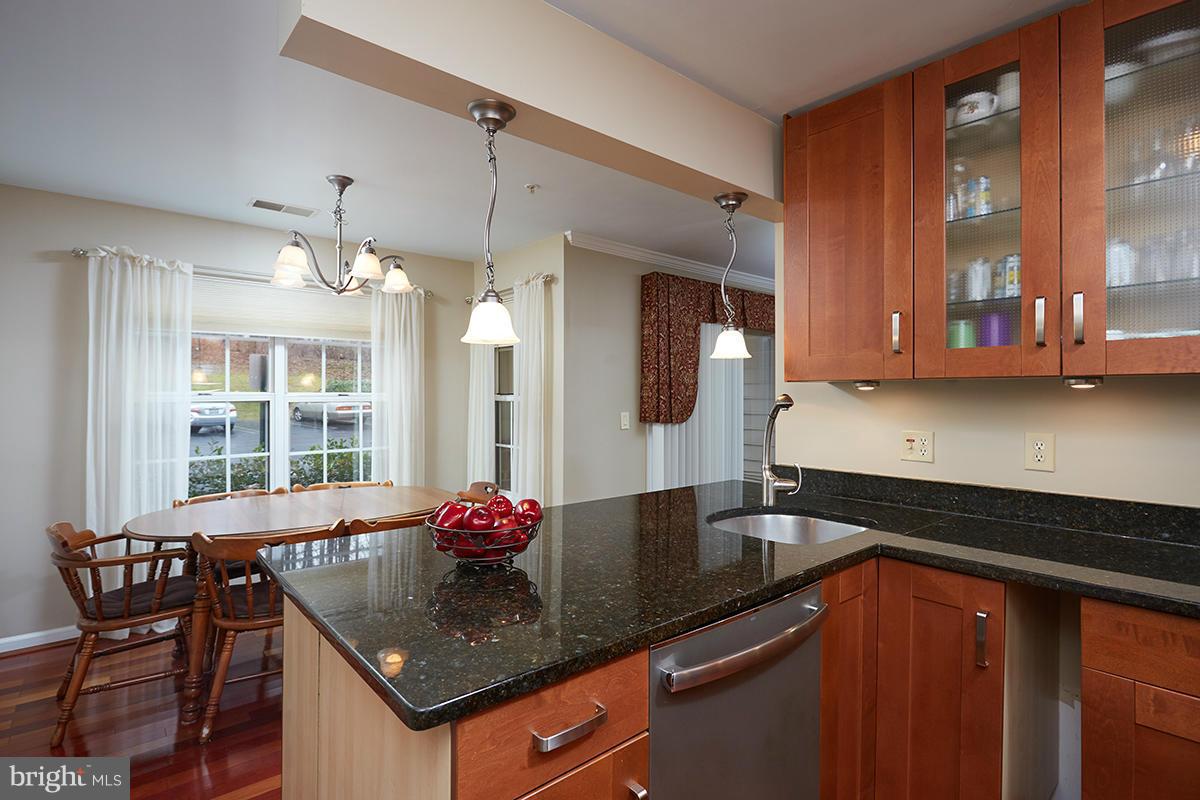 115 Timberbrook Lane, Unit 104 Gaithersburg, MD 20878 - Photo 8 of 28 a kitchen with granite countertop a sink cabinets and window
