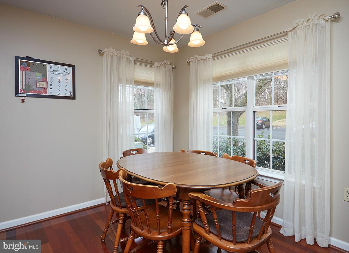 115 Timberbrook Lane, Unit 104 Gaithersburg, MD 20878 - Photo 10 of 28 a view of a dining room with furniture window and wooden floor