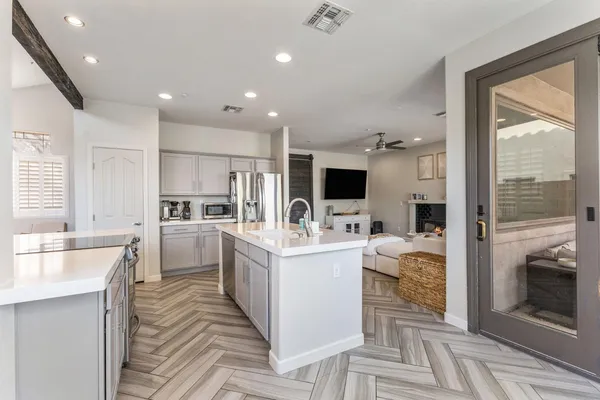a kitchen with a stove a sink a dining table and chairs with wooden floor