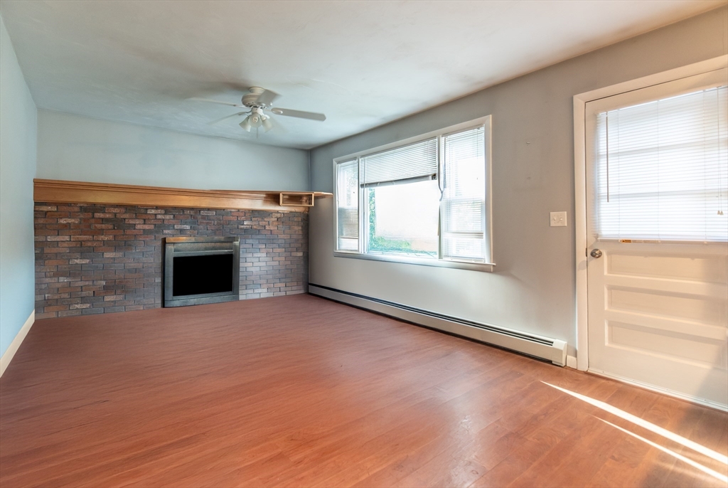 an empty room with windows fireplace and a sink