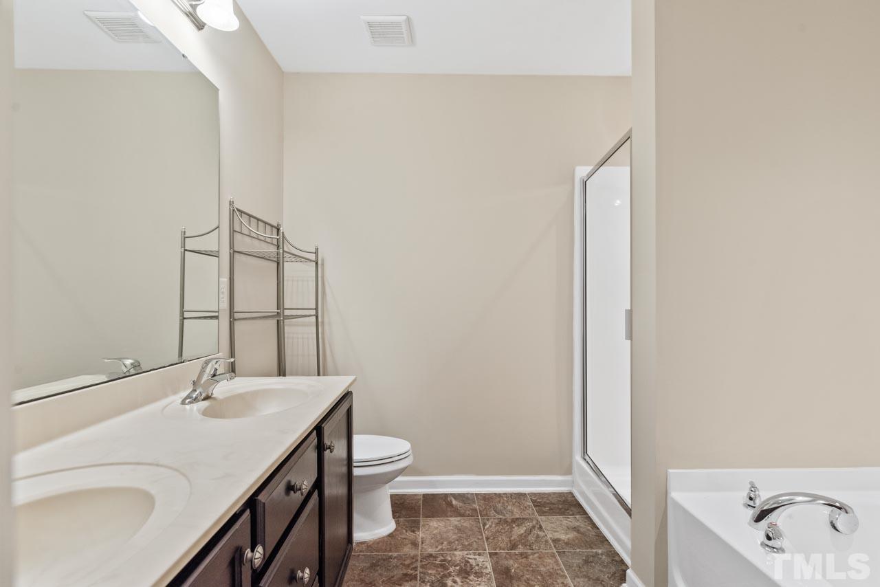7705 Weathered Oak Way Raleigh, NC 27616 - Photo 15 of 26 a bathroom with a sink a toilet and shower