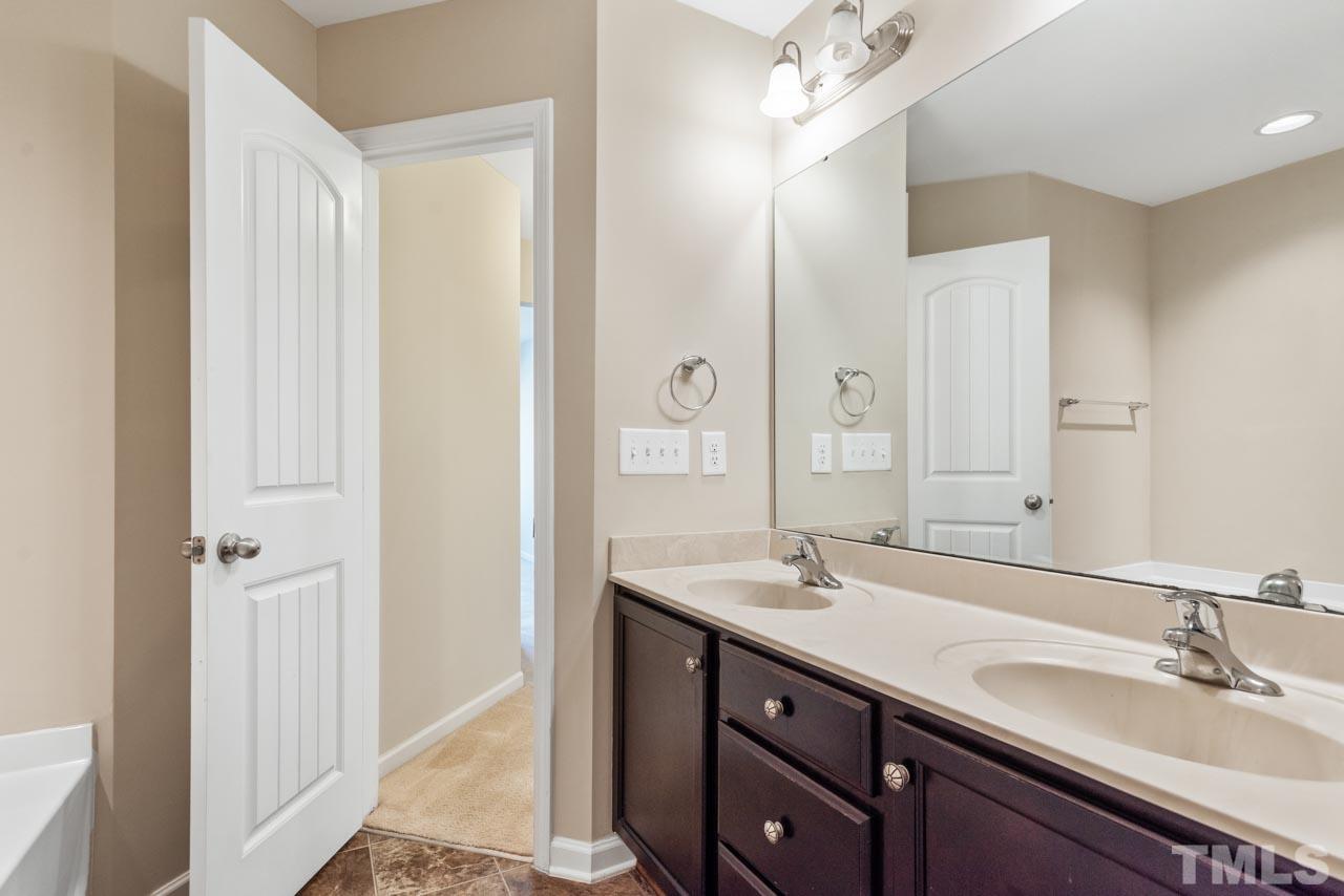 7705 Weathered Oak Way Raleigh, NC 27616 - Photo 16 of 26 a bathroom with a double vanity sink and a mirror