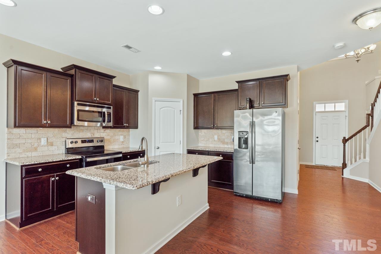 7705 Weathered Oak Way Raleigh, NC 27616 - Photo 3 of 26 a kitchen with stainless steel appliances granite countertop a refrigerator stove microwave and sink