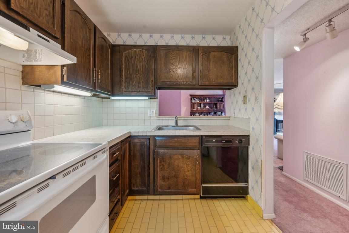 25 Church Road, Unit 150 Maple Shade, NJ 08052 - Photo 16 of 22 a kitchen with stainless steel appliances wooden cabinets and a wooden floor