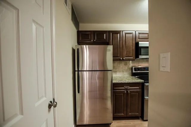 a metallic refrigerator freezer sitting in a kitchen