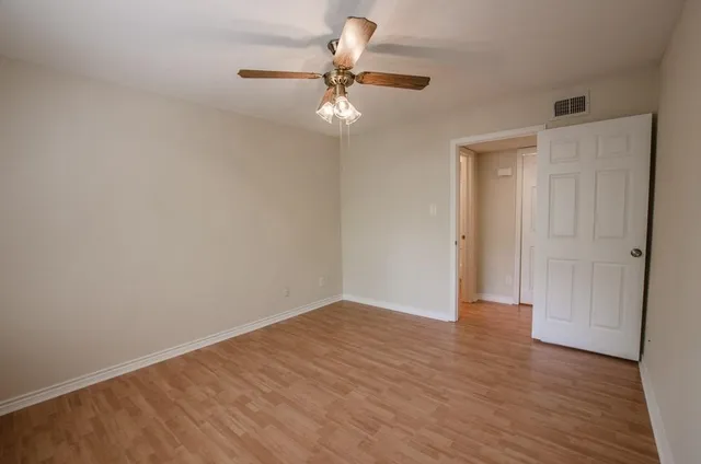 a view of an empty room with wooden floor