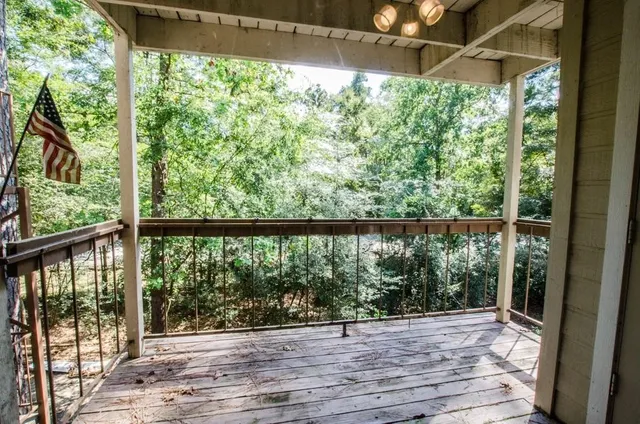 a view of a room with a large window and wooden floor