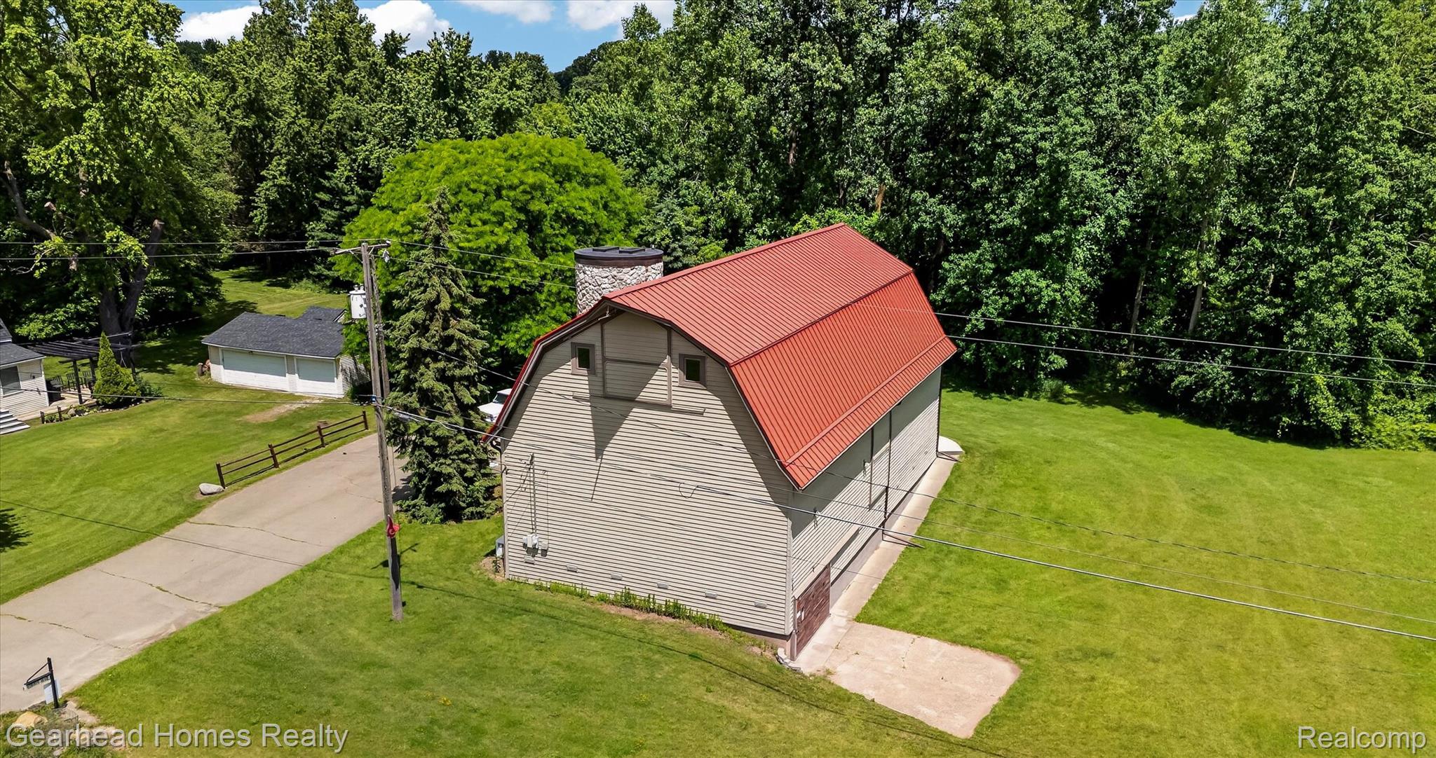 3486 West Drahner Road Oxford, MI 48371 - Photo 37 of 51 Gambrel-roof structure with a red metal roof and light-toned siding