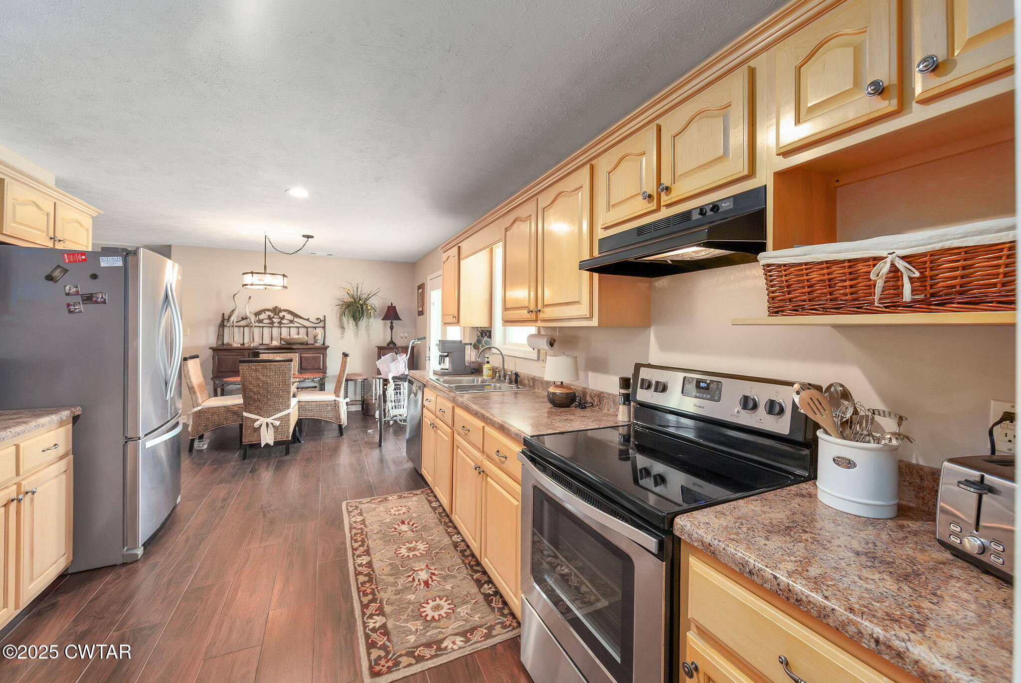 114 Falcon Cove Middleton, TN 38052 - Photo 3 of 24 a kitchen with stainless steel appliances granite countertop a stove top oven a refrigerator a sink dishwasher and wooden cabinets with wooden floor